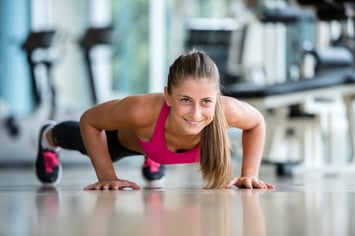 Gorgeous blonde woman warming up and doing some push ups a the gym.jpeg