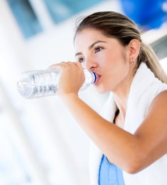Woman drinking water at the gym after working out.jpeg